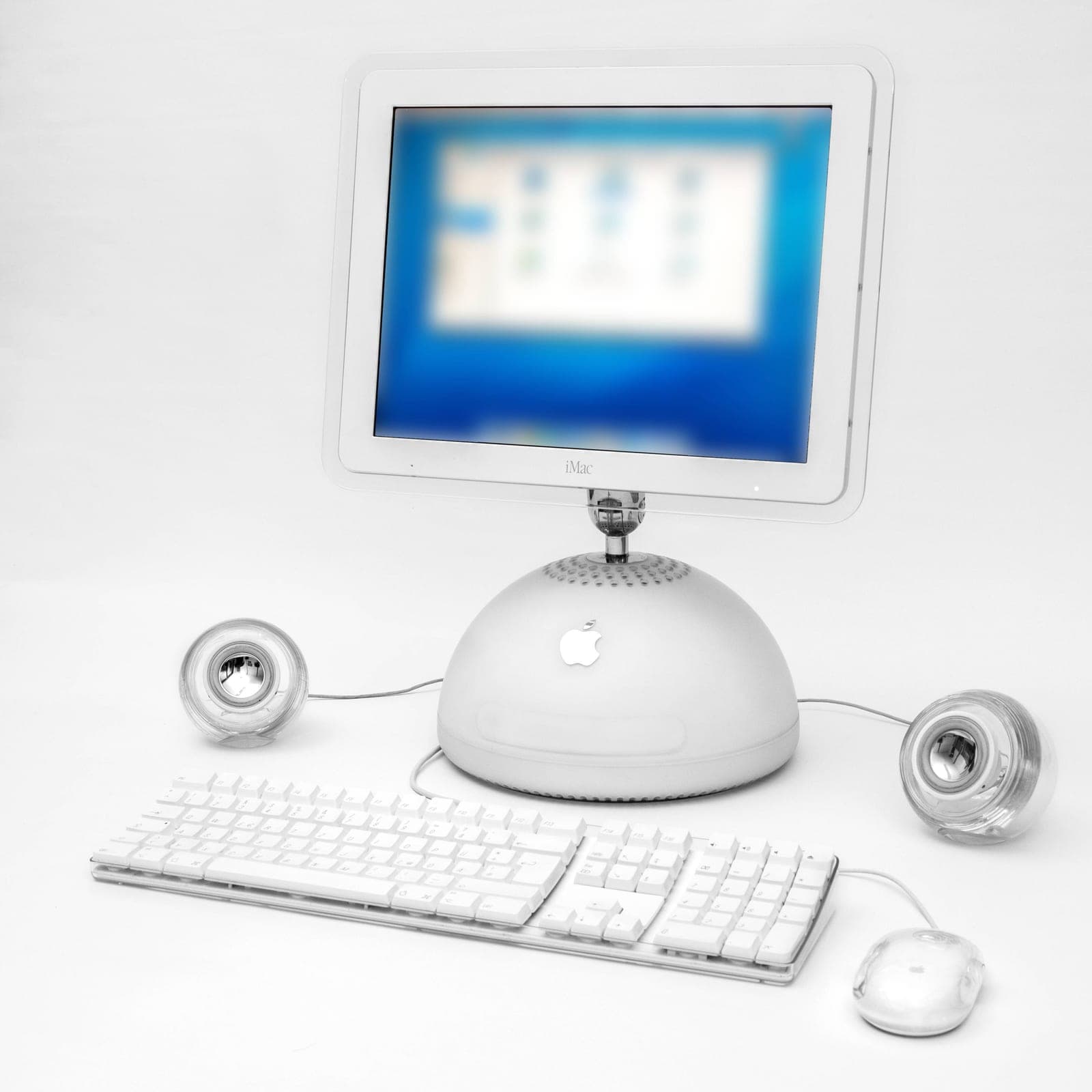 iMac G4 with keyboard, mouse and speakers on a white background